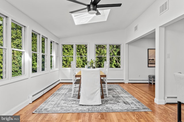 sunroom with vaulted ceiling with skylight, ceiling fan, and a baseboard heating unit