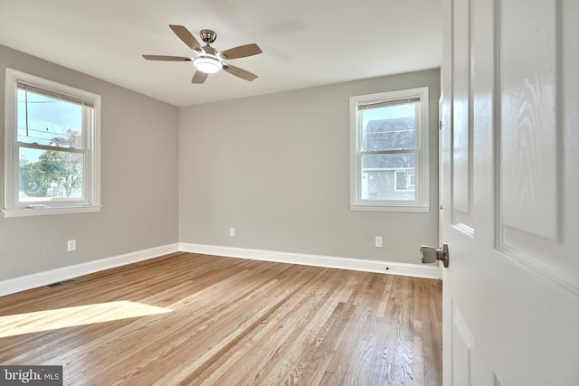 spare room with ceiling fan, a healthy amount of sunlight, and light hardwood / wood-style floors