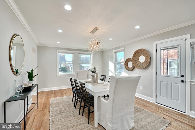 dining room with plenty of natural light, ornamental molding, and light hardwood / wood-style flooring