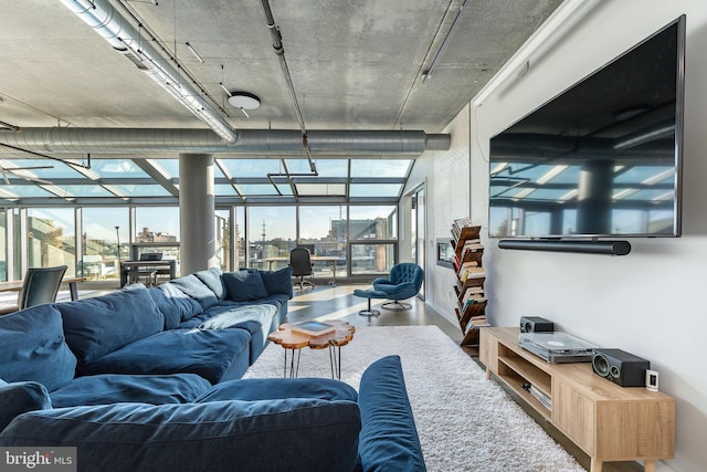 living room with a wall of windows and concrete floors