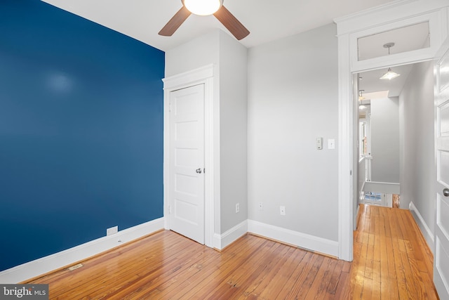 empty room with ceiling fan and light wood-type flooring