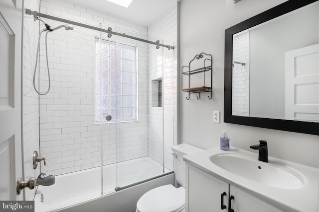 full bathroom with vanity, bath / shower combo with glass door, and toilet