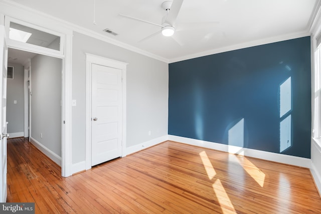 spare room featuring ceiling fan, wood-type flooring, and ornamental molding