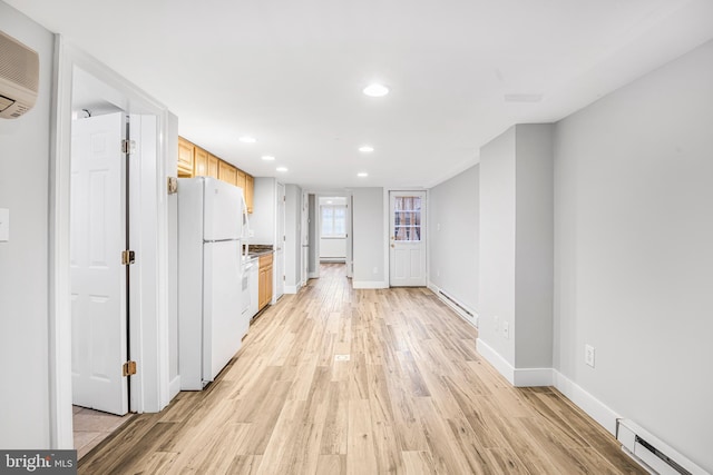 kitchen featuring white fridge, light hardwood / wood-style flooring, light brown cabinetry, and a baseboard heating unit