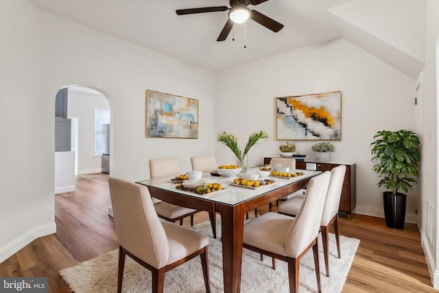 dining area featuring ceiling fan, light hardwood / wood-style flooring, and vaulted ceiling