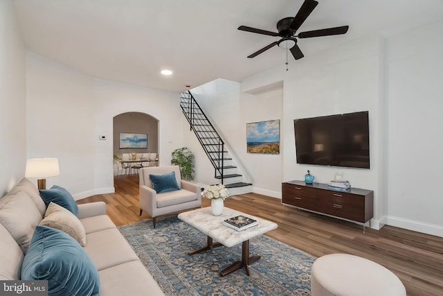 living room featuring wood-type flooring and ceiling fan