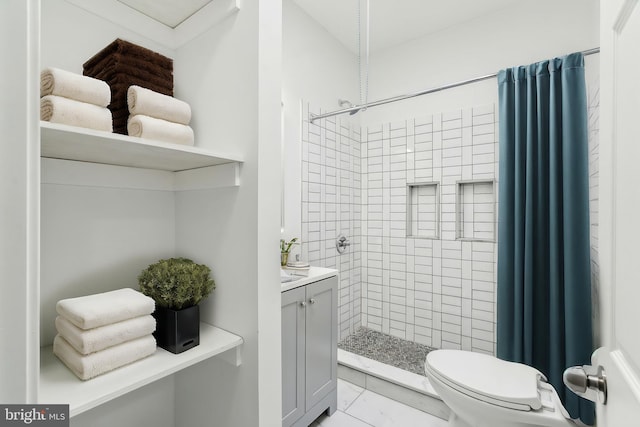 bathroom with walk in shower, vanity, and toilet