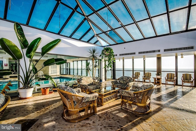 sunroom / solarium featuring a water view and a skylight