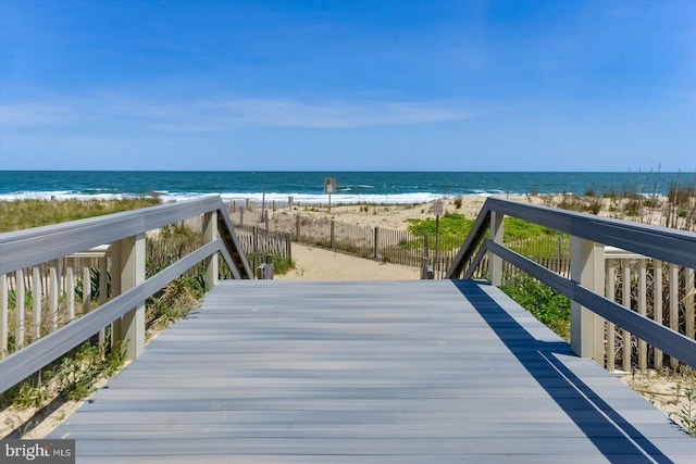 wooden terrace with a view of the beach and a water view