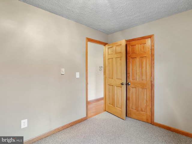 unfurnished bedroom featuring a textured ceiling and carpet floors