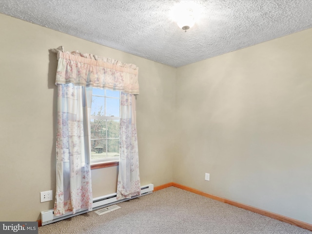 carpeted empty room featuring a textured ceiling