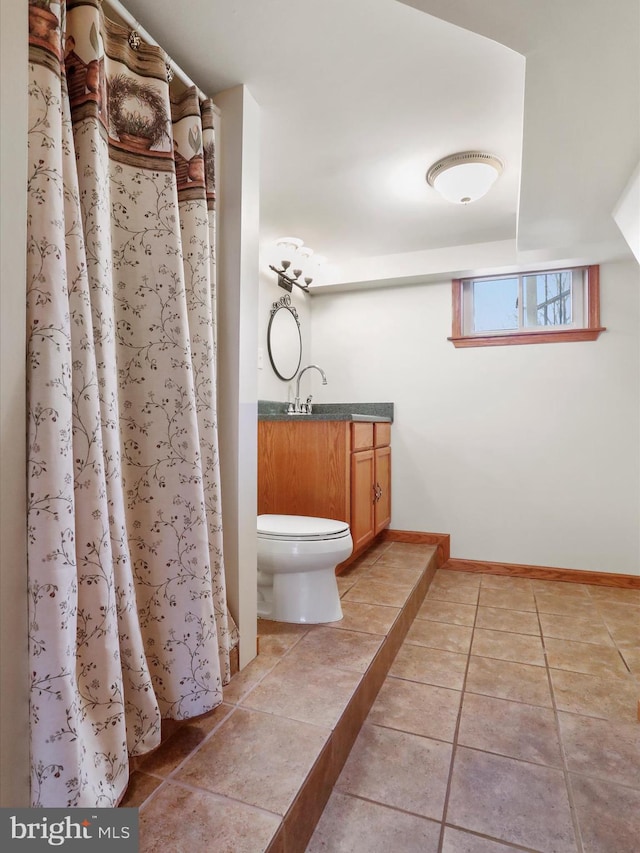 bathroom with toilet, vanity, tile patterned floors, and walk in shower