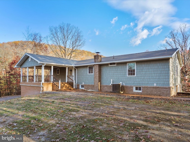 rear view of property featuring a porch and cooling unit