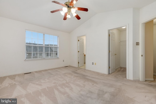 unfurnished bedroom with lofted ceiling, ceiling fan, a spacious closet, light colored carpet, and a closet