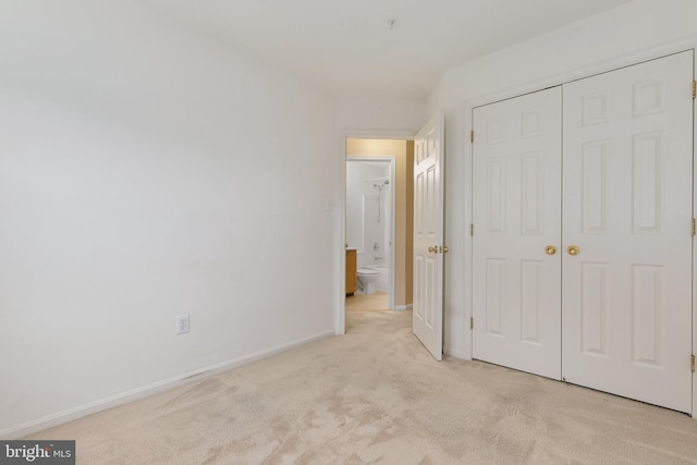 unfurnished bedroom with light carpet and a closet