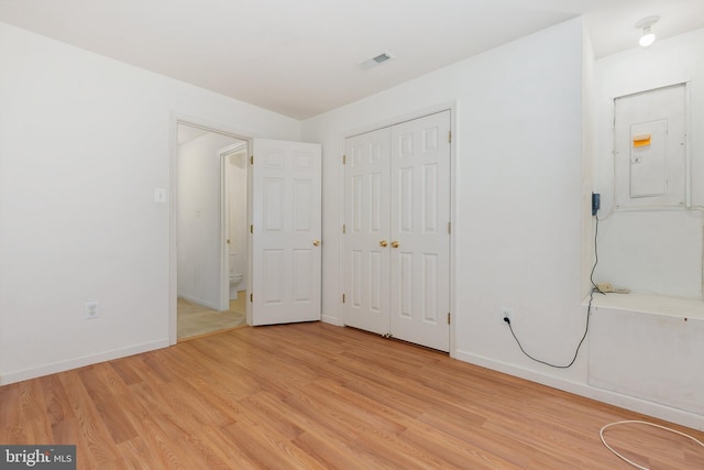 unfurnished bedroom featuring light wood-type flooring and electric panel