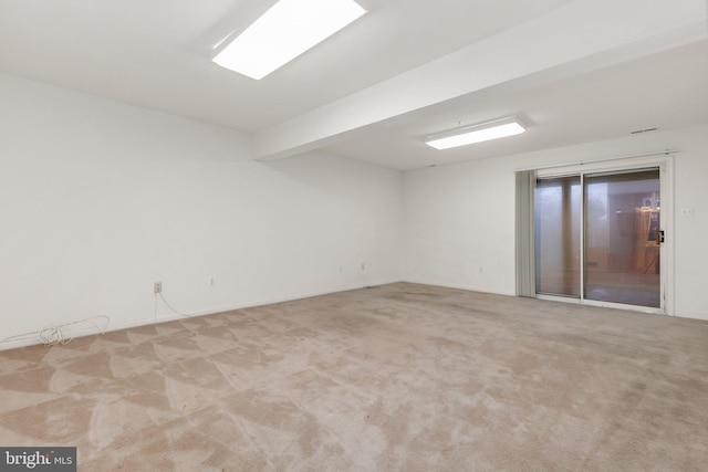 unfurnished room with light carpet and beam ceiling