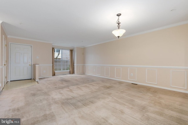 spare room featuring light colored carpet and ornamental molding