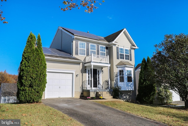 view of front of home with solar panels, a garage, and a front lawn