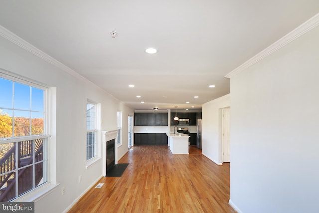 unfurnished living room featuring crown molding, sink, and hardwood / wood-style flooring