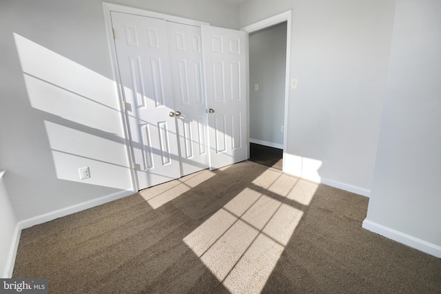 spare room with dark colored carpet