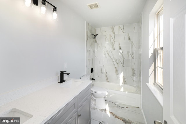 full bathroom with toilet, vanity, and tiled shower / bath