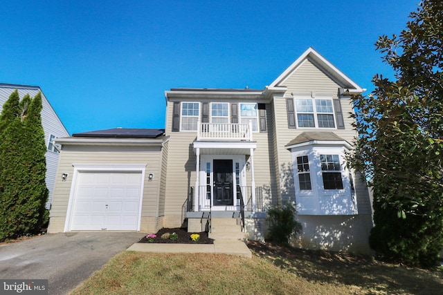 view of front of home with a garage, a balcony, and a front lawn