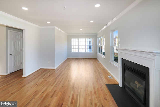 unfurnished living room featuring ornamental molding and light wood-type flooring