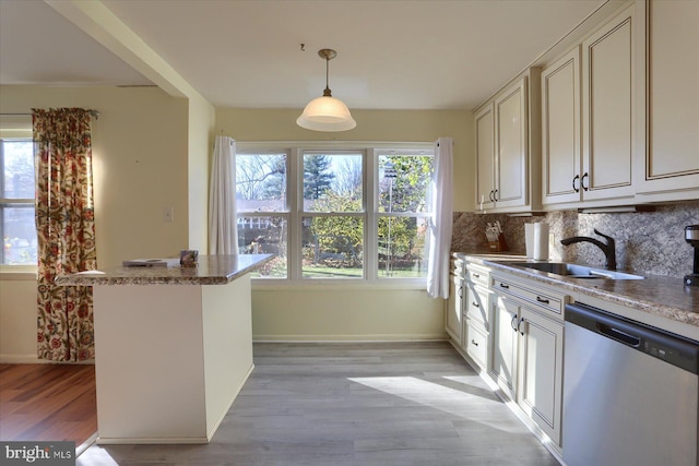 kitchen featuring sink, decorative light fixtures, plenty of natural light, dishwasher, and decorative backsplash