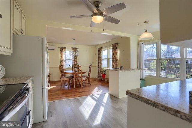 kitchen with pendant lighting, light hardwood / wood-style flooring, and stainless steel range with electric stovetop