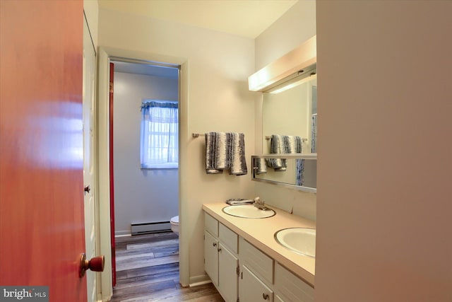 bathroom featuring baseboard heating, vanity, toilet, and hardwood / wood-style flooring