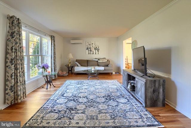 living room featuring ornamental molding, a wall mounted AC, and light hardwood / wood-style flooring