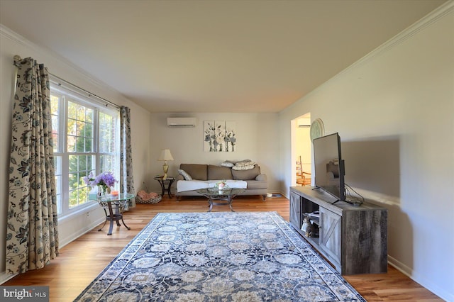 living room with ornamental molding, light hardwood / wood-style flooring, and a wall unit AC