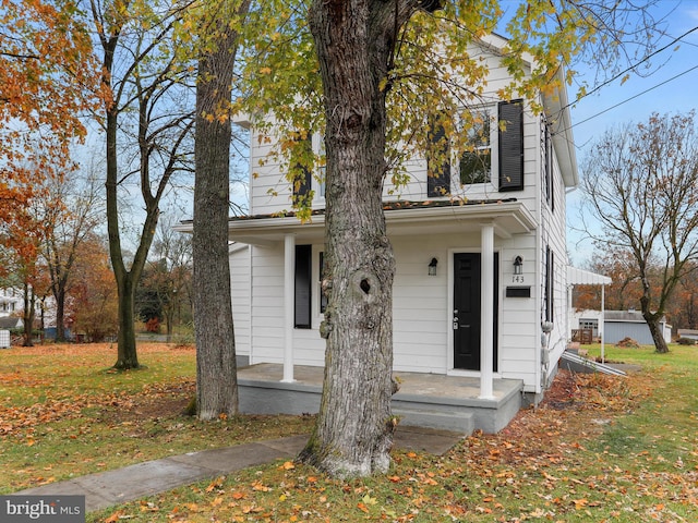 view of front of home featuring covered porch and a front lawn