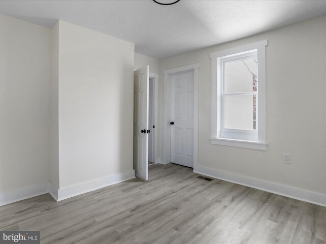 unfurnished room featuring light wood-type flooring and plenty of natural light