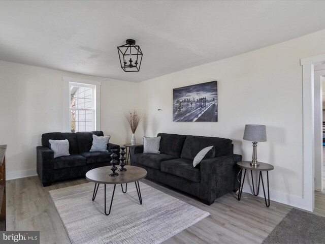 living room featuring light hardwood / wood-style floors and an inviting chandelier