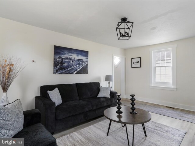 living room featuring a notable chandelier and light hardwood / wood-style flooring