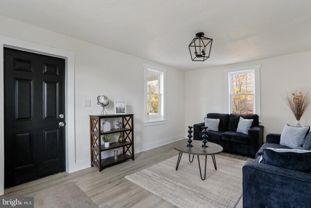 living room featuring a notable chandelier and light hardwood / wood-style flooring