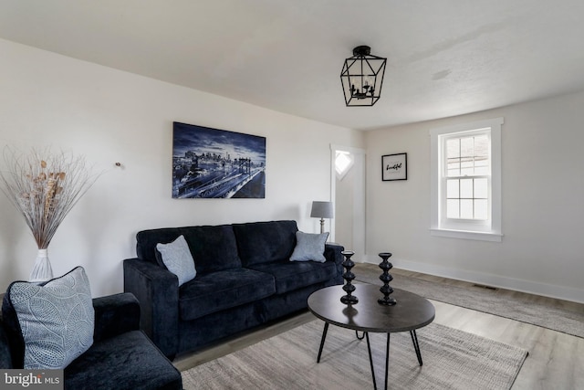 living room with an inviting chandelier and light hardwood / wood-style flooring