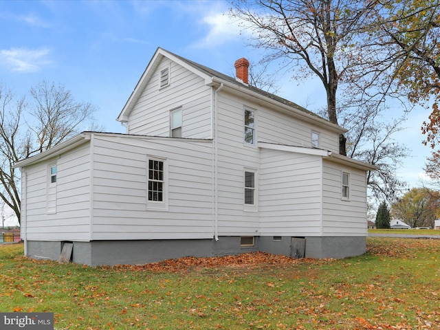 view of side of home with a yard