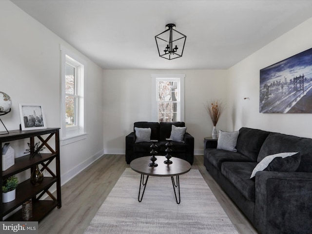 living room featuring light wood-type flooring and a notable chandelier