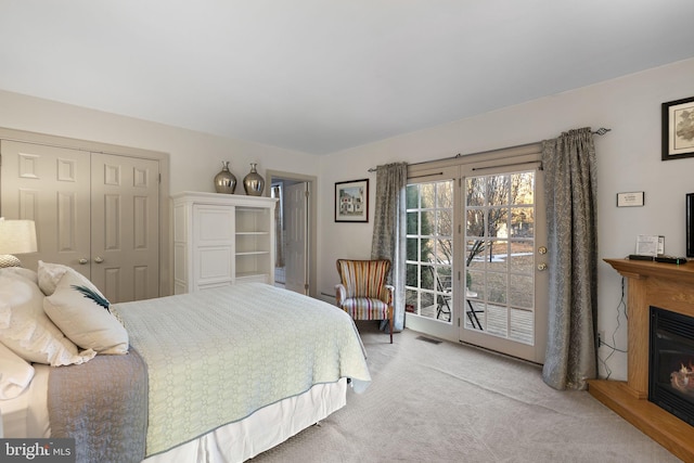 carpeted bedroom featuring access to exterior and a closet