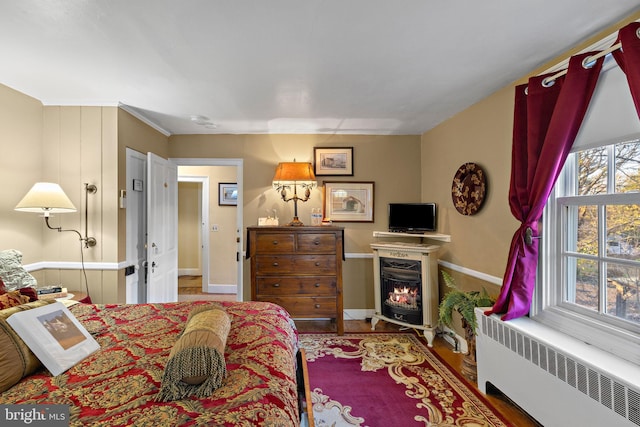 bedroom featuring hardwood / wood-style floors and radiator heating unit