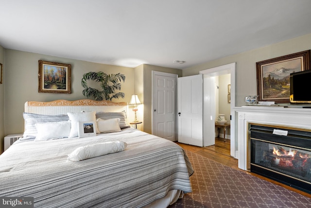 1324 River Rd, New Hope, PA 18938 - bedroom with wood finished floors, ensuite bath, and a glass covered fireplace