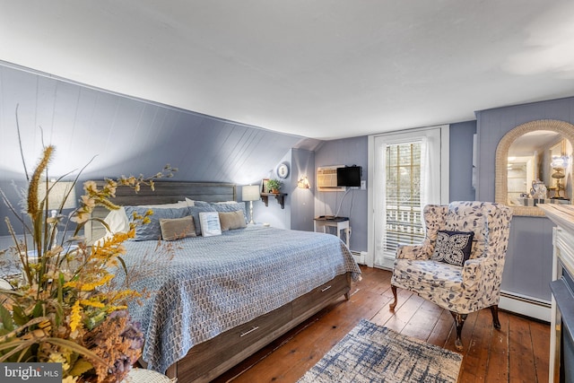 bedroom with dark hardwood / wood-style flooring, a baseboard radiator, and vaulted ceiling