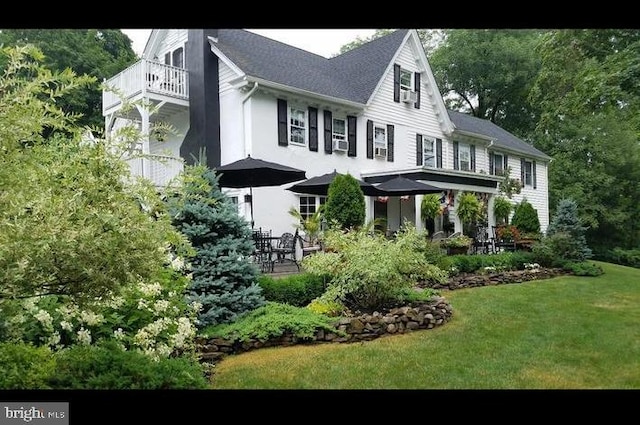 view of front facade featuring a gazebo, a balcony, and a front yard