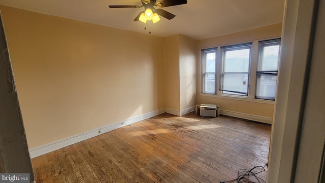 unfurnished room with hardwood / wood-style flooring, an AC wall unit, and ceiling fan