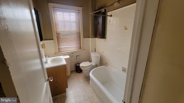 bathroom with vanity, a bathing tub, tile patterned flooring, toilet, and tile walls