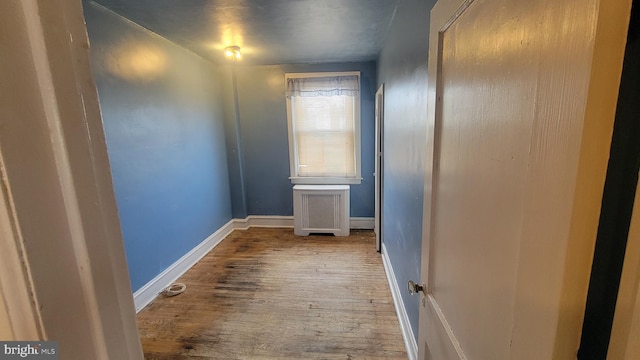 hall with radiator and hardwood / wood-style flooring