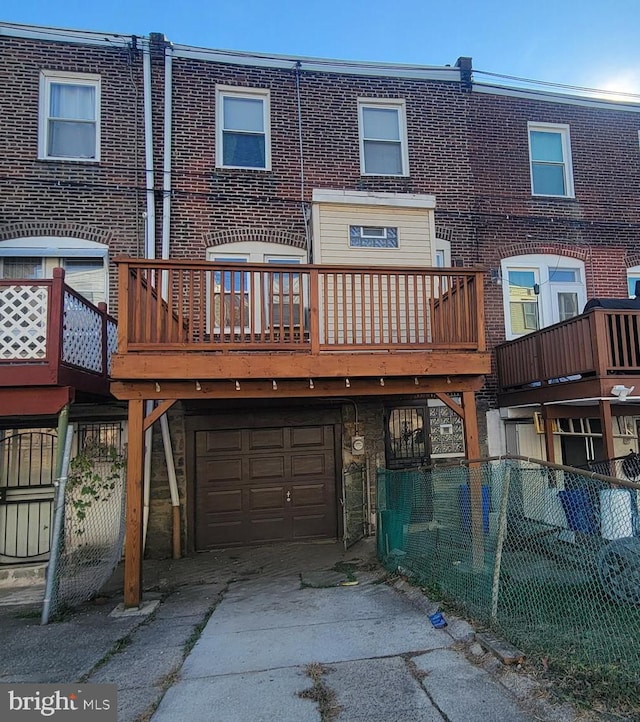 back of property with a garage and a deck